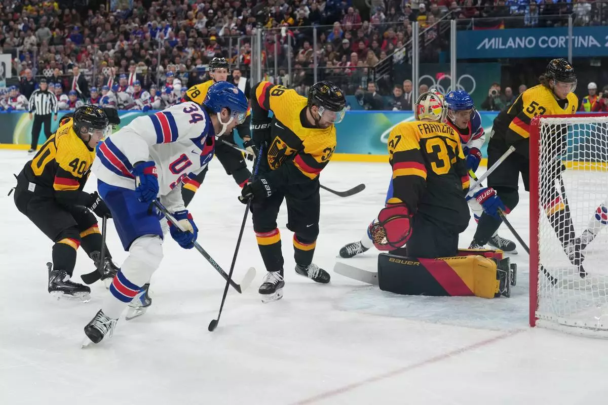 United States' Auston Matthews, right, scores his side's second goal during a preliminary round game of men's ice hockey between the United States and Germany at the 2026 Winter Olympics, in Milan, Italy, Sunday, Feb. 15, 2026. (AP Photo/Carolyn Kaster)