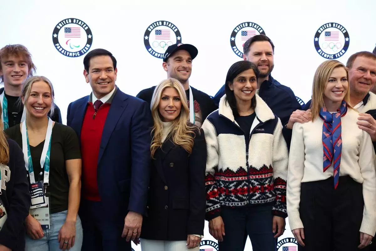 Vice President JD Vance, second lady Usha Vance, Secretary of State Marco Rubio his wife Jeanette Dousdebes Rubio and U.S. Ambassador to Italy and San Marino Tilman Fertitta pose for a photo with Team USA athletes, at the Team USA Welcome Experience, ahead of the Milano Cortina 2026 Winter Olympics in Milan, Italy, Thursday, Feb. 5, 2026. (Kevin Lamarque/Pool Photo via AP)