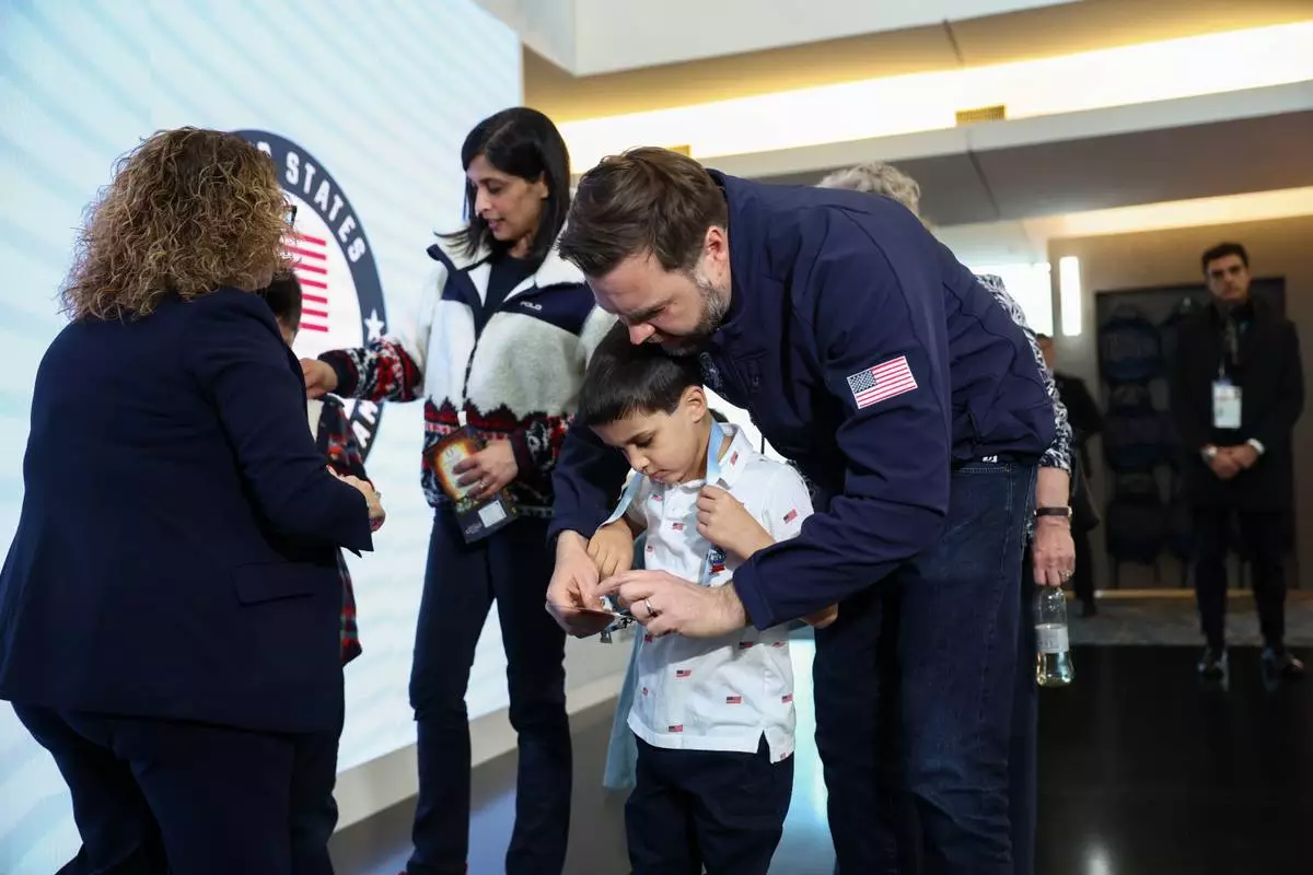 Vice President JD Vance holds his son Vivek's credentials, at the Team USA Welcome Experience, ahead of the Milano Cortina 2026 Winter Olympics in Milan, Italy, Thursday, Feb. 5, 2026. (Kevin Lamarque/Pool Photo via AP)