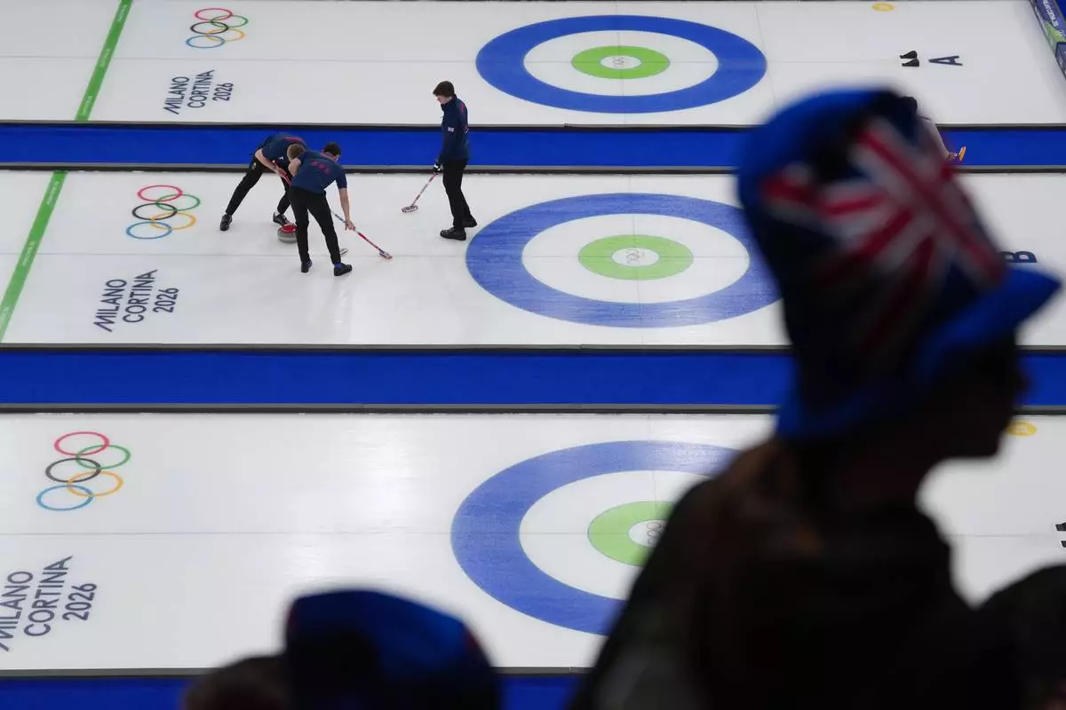 Britain's Bruce Mouat, Grant Hardie and Bobby Lammie competes in a men's curling semifinal match against Switzerland at the 2026 Winter Olympics, in Cortina d'Ampezzo, Italy, Thursday, Feb. 19, 2026. (AP Photo/Misper Apawu)