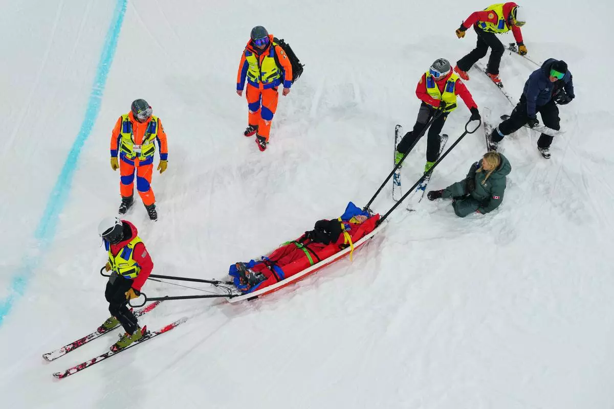Medics stretcher off Canada's Cassie Sharpe after she crashed during the women's freestyle skiing halfpipe qualifications at the 2026 Winter Olympics, in Livigno, Italy, Thursday, Feb. 19, 2026. (AP Photo/Julia Demaree Nikhinson)