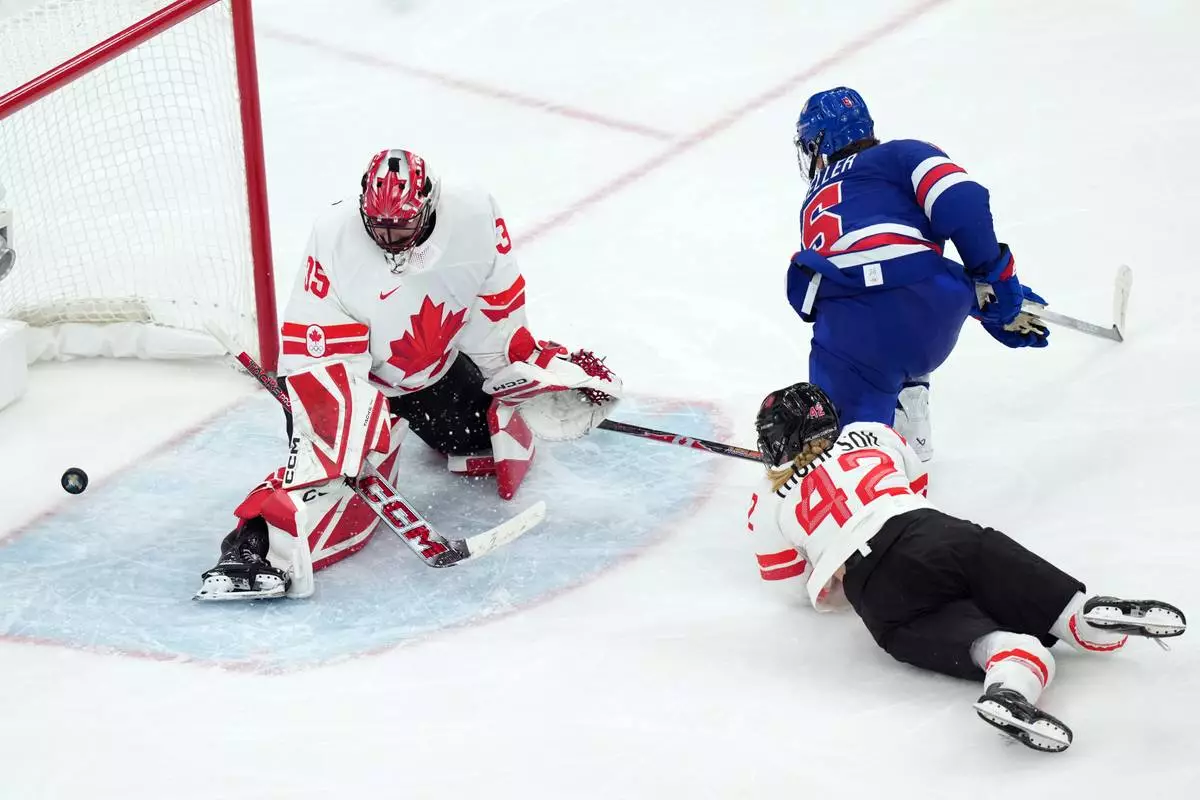 United States' Megan Keller (5) scores the winning goal against Canada goalkeeper Ann-Renee Desbiens (35) during the overtime period of the women's ice hockey gold medal game at the 2026 Winter Olympics, in Milan, Italy, Thursday, Feb. 19, 2026. (AP Photo/Carolyn Kaster)