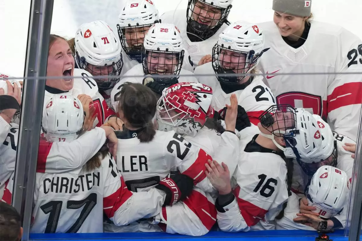 Team Switzerland players celebrate after beating Sweden 2-1 in overtime to win the women's ice hockey bronze medal game at the 2026 Winter Olympics, in Milan, Italy, Thursday, Feb. 19, 2026. (AP Photo/Carolyn Kaster)