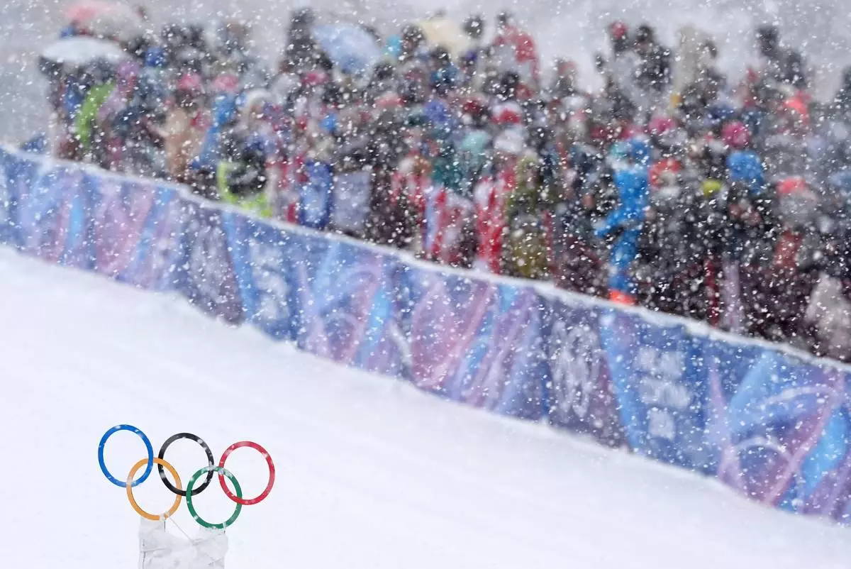 Spectators watch a ski mountaineering men's sprint heat under a snowfall at the 2026 Winter Olympics in Bormio, Italy, Thursday, Feb. 19, 2026. (AP Photo/Rebecca Blackwell)