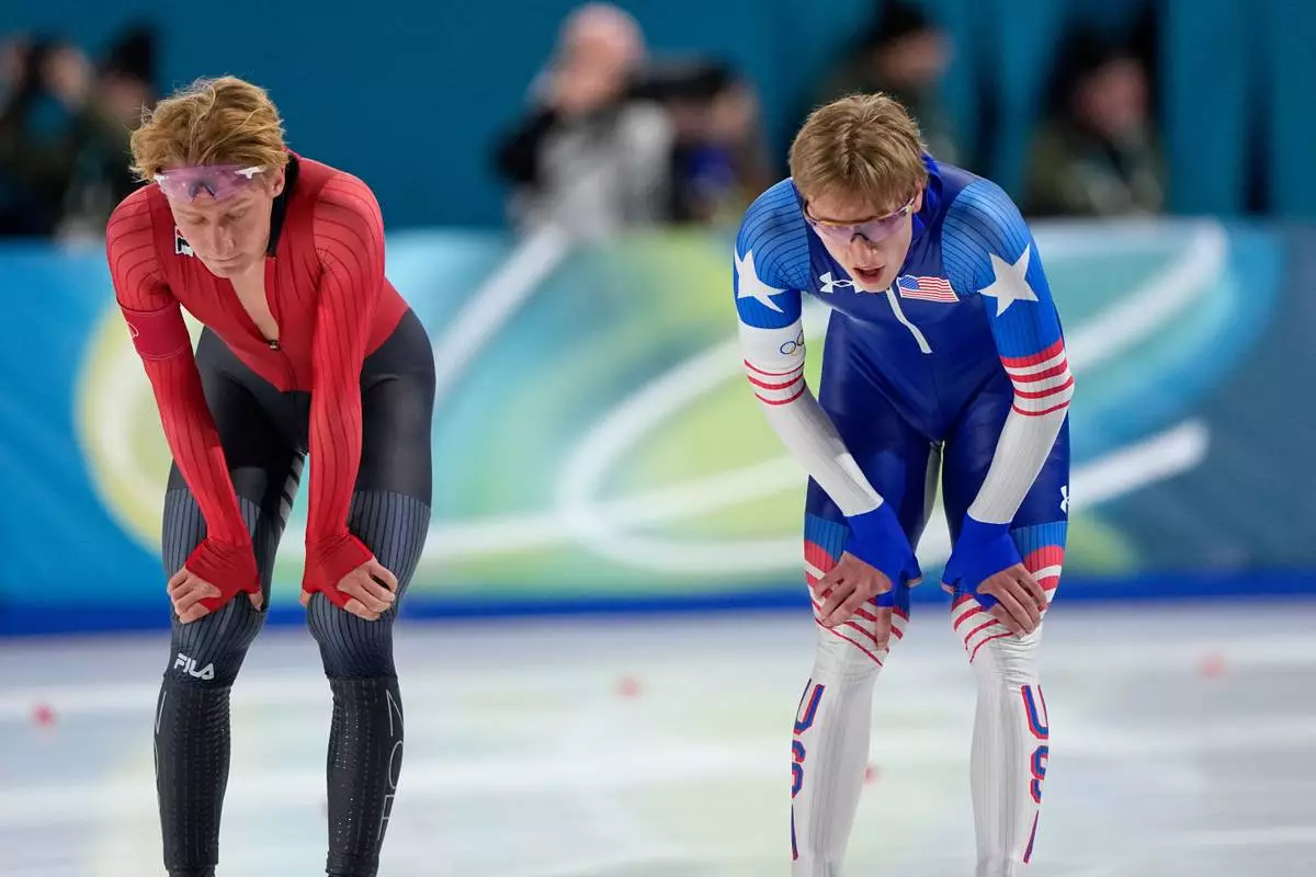 Jordan Stolz of the U.S., right, and Peder Kongshaug of Norway catch their breath after competing in the men's 1500 meters speedskating race at the 2026 Winter Olympics, in Milan, Italy, Thursday, Feb. 19, 2026. (AP Photo/Ben Curtis)