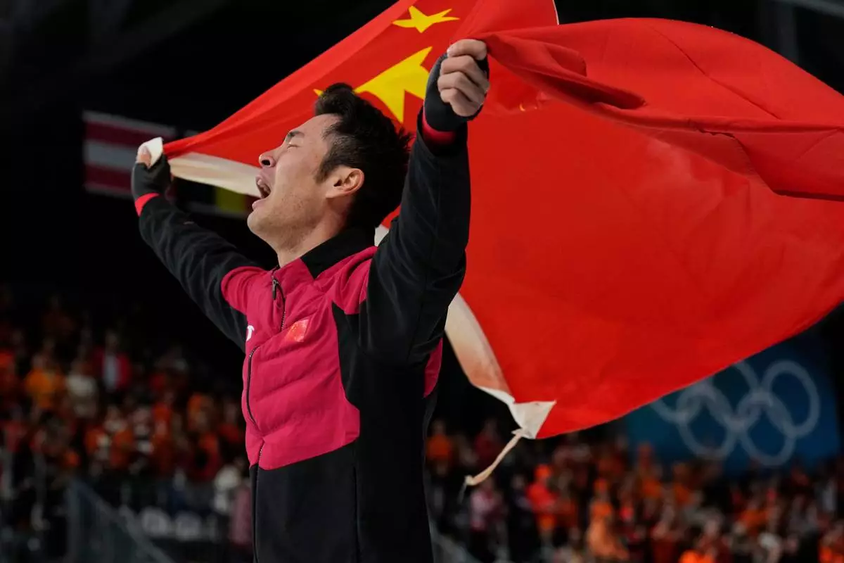 Ning Zhongyan of China celebrates winning the gold medal in the men's 1500 meters speedskating race at the 2026 Winter Olympics, in Milan, Italy, Thursday, Feb. 19, 2026. (AP Photo/Luca Bruno)