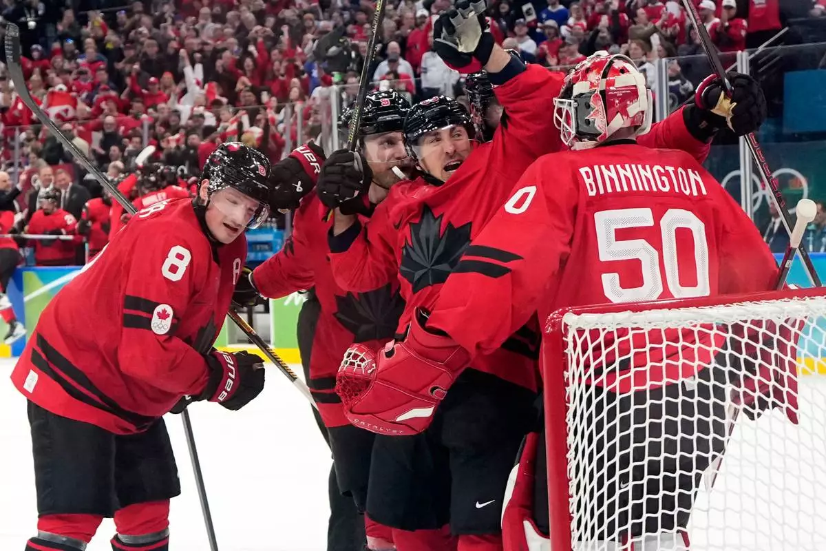 Canada players celebrate at the end of a men's ice hockey semifinal game between Canada and Finland at the 2026 Winter Olympics, in Milan, Italy, Friday, Feb. 20, 2026. (AP Photo/Hassan Ammar)