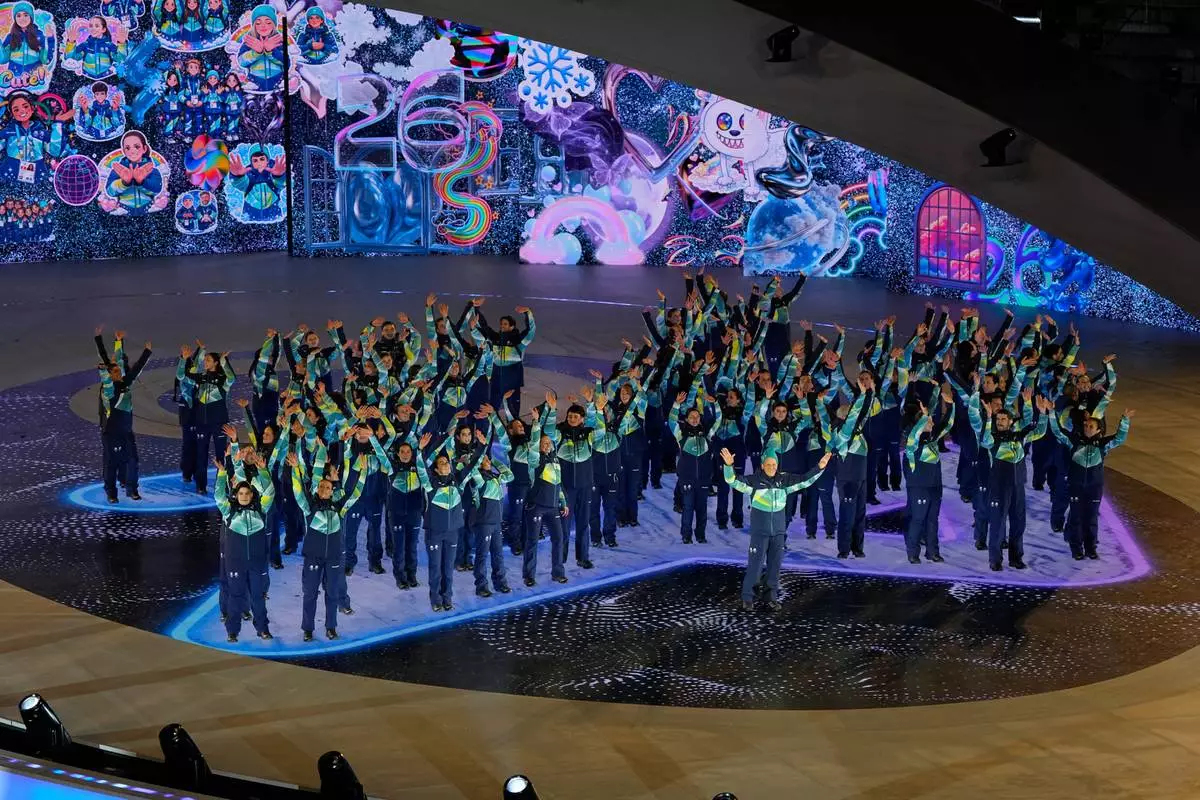 Olympic volunteers during the closing ceremony of the 2026 Winter Olympics, in Verona, Italy, Sunday, Feb. 22, 2026. (AP Photo/Ashley Landis)