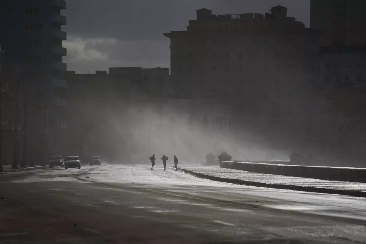People walk along the Malecón in Havana, Monday, Feb. 23, 2026. (AP Photo/Ramon Espinosa)