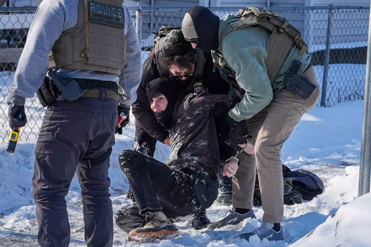 FILE - A person is detained by federal agents in Minneapolis, Feb. 3, 2026. (AP Photo/Ryan Murphy, File)