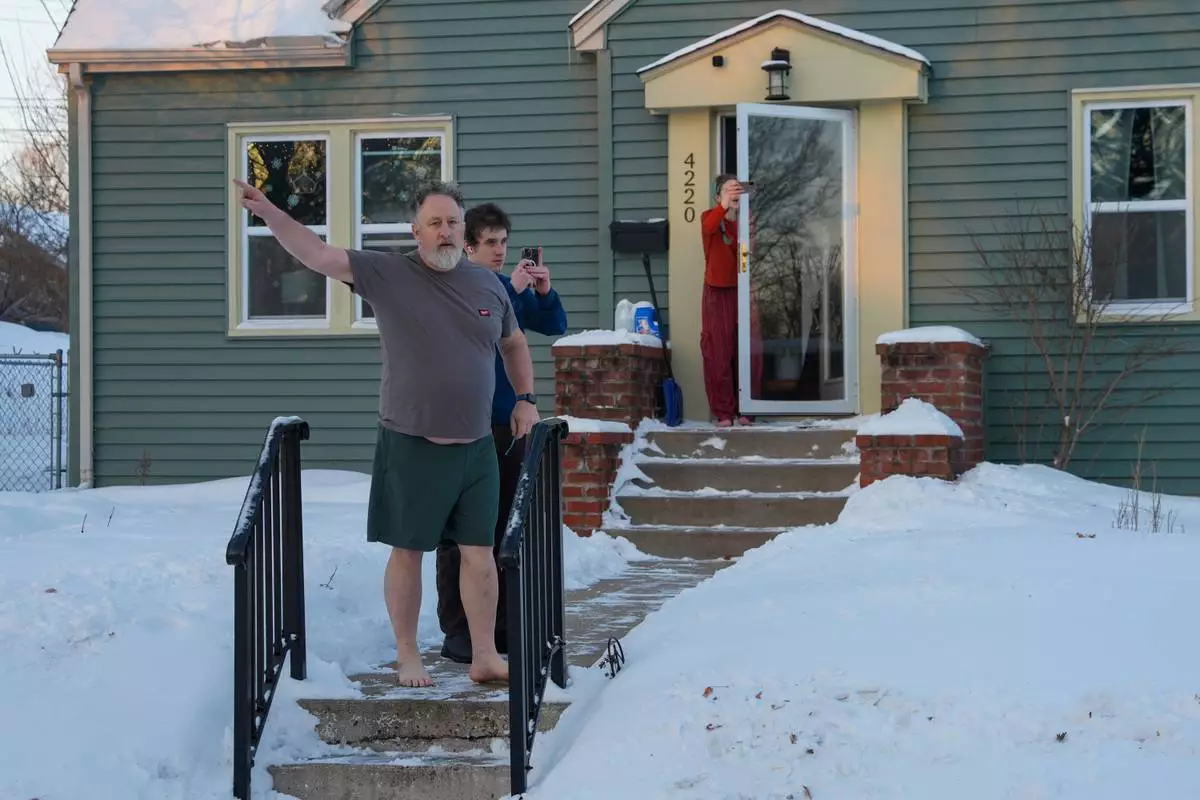 FILE - Residents film and yell at federal agents to leave their neighborhood while agents conduct immigration enforcement operations in a neighborhood in Minneapolis, Feb. 2, 2026. (AP Photo/Ryan Murphy, File)