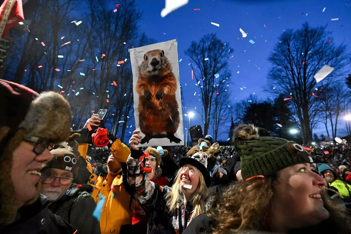 FILE - People take part in the festivities while waiting for Punxsutawney Phil, the weather prognosticating groundhog, to come out and make his prediction during the 139th celebration of Groundhog Day on Gobbler's Knob in Punxsutawney, Pa., Feb. 2, 2025. (AP Photo/Barry Reeger, File)