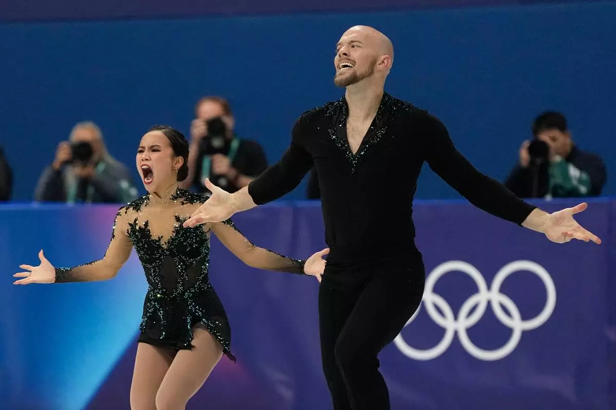 Ellie Kam and Danny O'Shea of the United States compete during the figure skating pairs team event at the 2026 Winter Olympics, in Milan, Italy, Sunday, Feb. 8, 2026. (AP Photo/Ashley Landis)