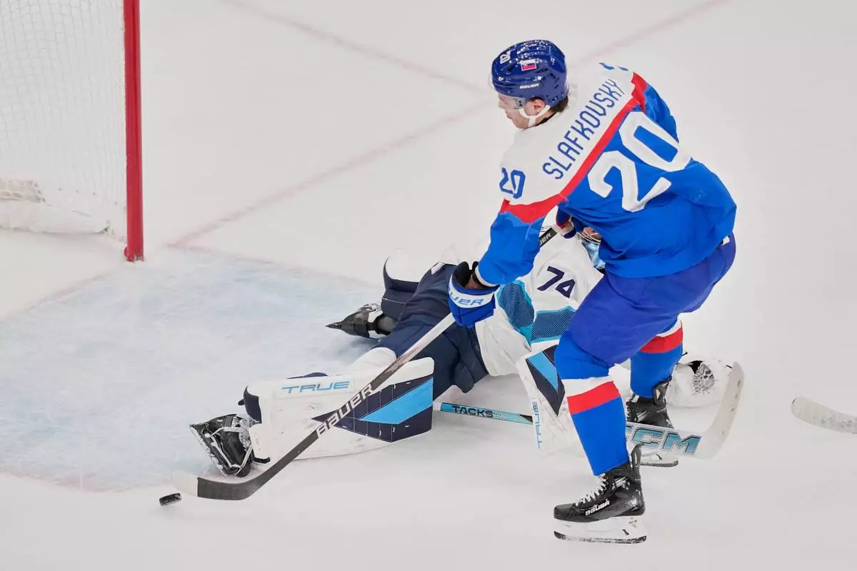 Slovakia's Juraj Slafkovsky (20) scores her side's opening goal during a preliminary round match of men's ice hockey between Slovakia and Finland at the 2026 Winter Olympics, in Milan, Italy, Wednesday, Feb. 11, 2026. (AP Photo/Petr David Josek)