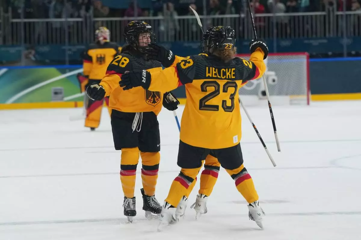Germany's Katarina Jobst-Smith (28) celebrates scoring the winning goal with Germany's Lilli Welcke (23) in overtime against France during a preliminary round match of women's ice hockey at the 2026 Winter Olympics, in Milan, Italy, Monday, Feb. 9, 2026. (AP Photo/Carolyn Kaster)