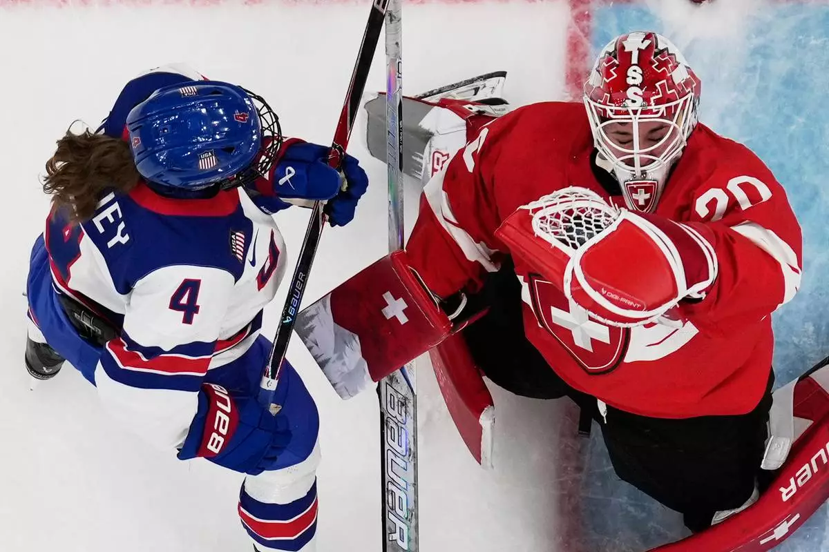 Switzerland's Andrea Brandli makes a save against United States' Caroline Harvey during a preliminary round match of women's ice hockey between the United States and Switzerland at the 2026 Winter Olympics, in Milan, Italy, Monday, Feb. 9, 2026. (AP Photo/Petr David Josek)