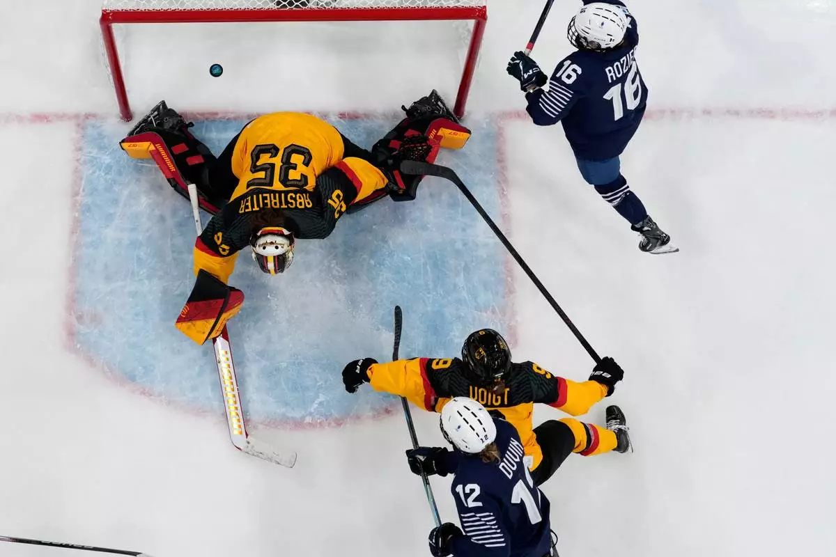 France's Estelle Duvin, bottom, scores her side's opening goal during a preliminary round match of women's ice hockey between Germany and France at the 2026 Winter Olympics, in Milan, Italy, Monday, Feb. 9, 2026. (AP Photo/Darko Bandic)