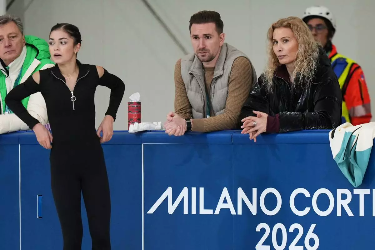Individual Neutral Athlete Adeliia Petrosian, left, speaks with choreographer Daniil Gleikhengauz, center, and coach Eteri Tutberidze, during a figure skating practice session at the 2026 Winter Olympics, in Milan, Italy, Monday, Feb. 16, 2026. (AP Photo/Stephanie Scarbrough)