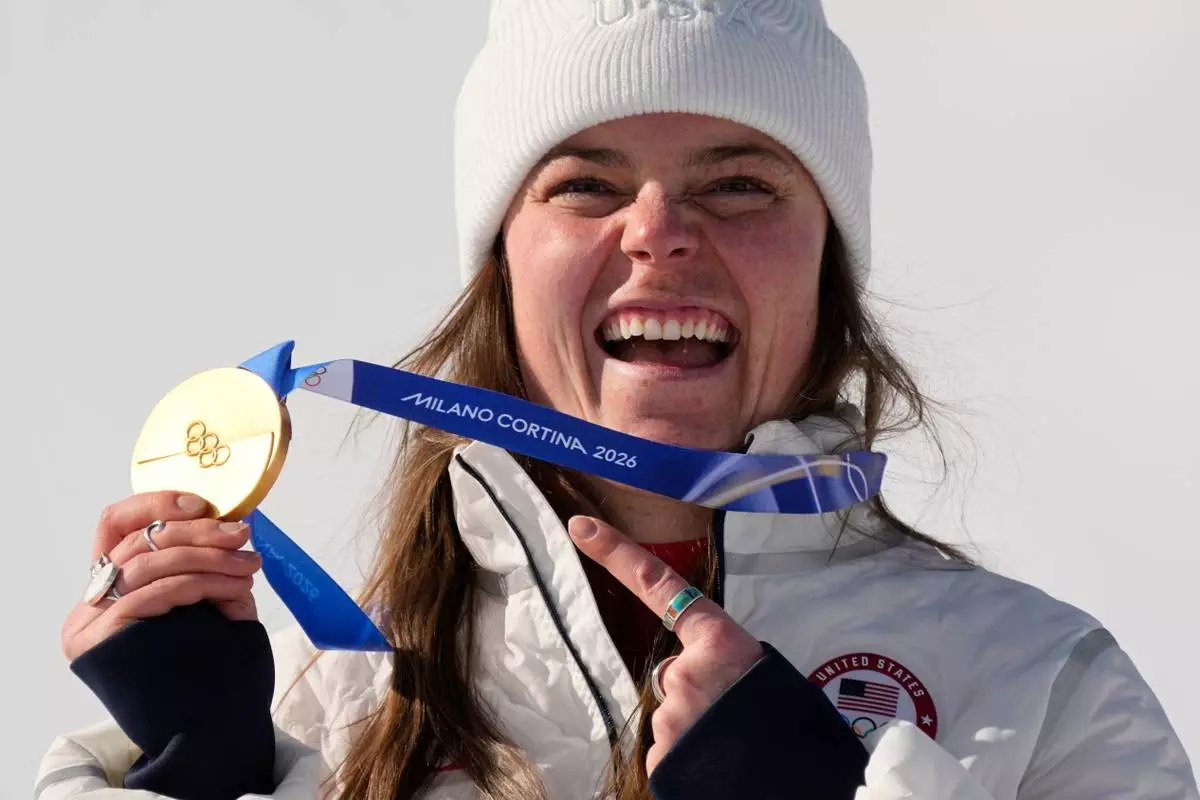 United States' Breezy Johnson shows her gold medal in the alpine ski women's downhill race, at the 2026 Winter Olympics, in Cortina d'Ampezzo, Italy, Sunday, Feb. 8, 2026. (AP Photo/Andy Wong)