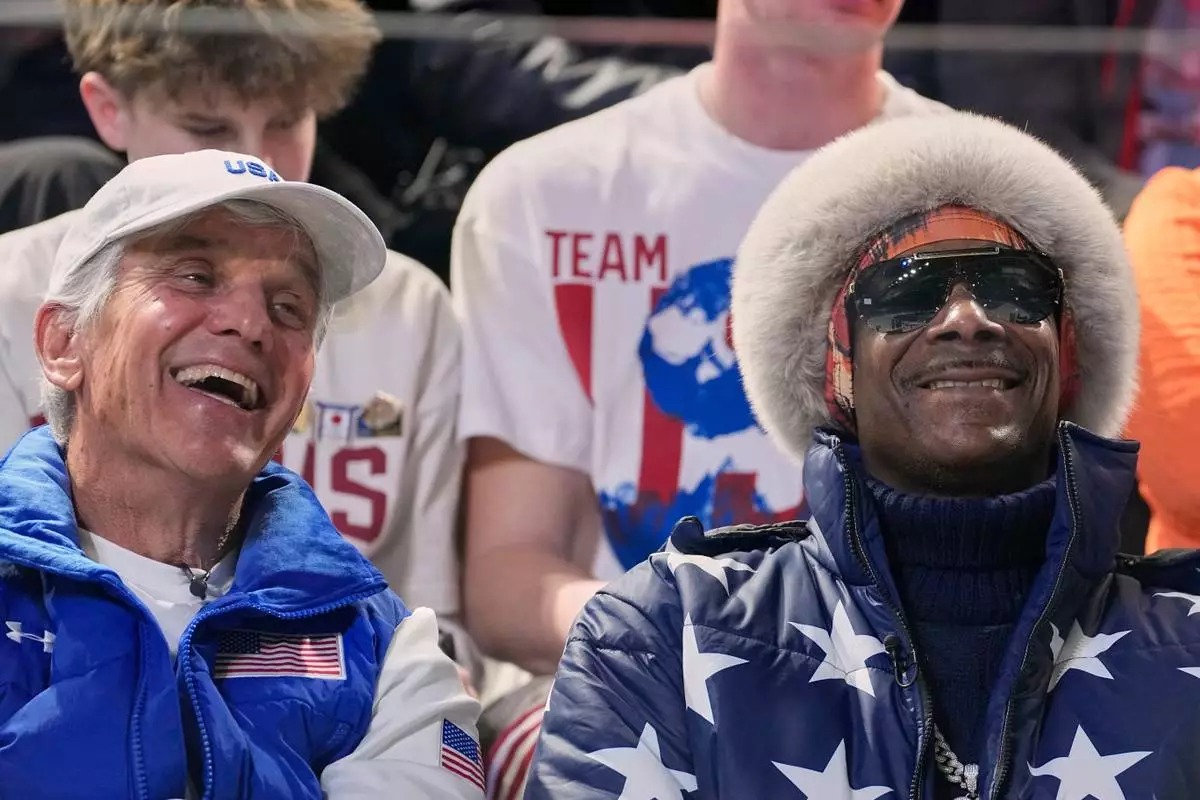Snoop dog and five-time olympic gold medallist former speed skater Eric Heiden of the U.S. watch the men's 1,000 meters speedskating race at the 2026 Winter Olympics, in Milan, Italy, Wednesday, Feb. 11, 2026. (AP Photo/Ben Curtis)