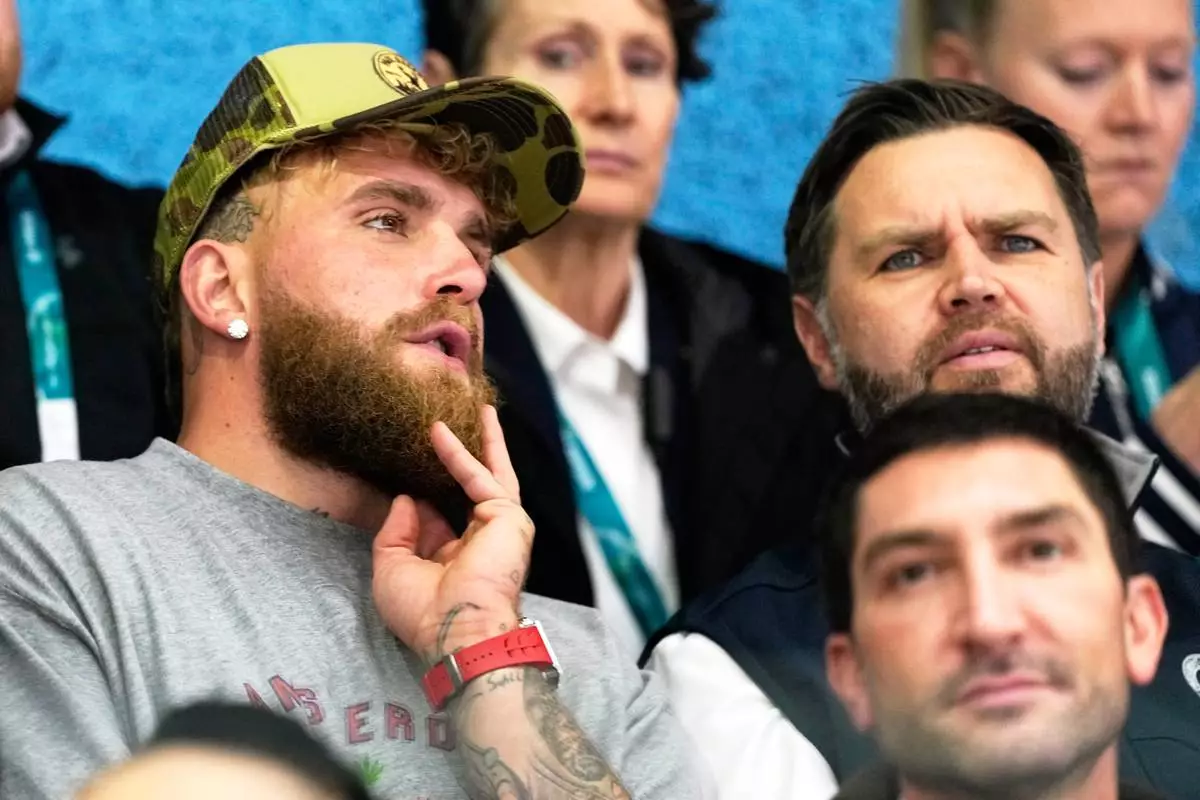 Jake Paul, left, and Vice President JD Vance attend a preliminary round match of women's ice hockey between the United States and Finland at the 2026 Winter Olympics, in Milan, Italy, Saturday, Feb. 7, 2026. (AP Photo/Petr David Josek)