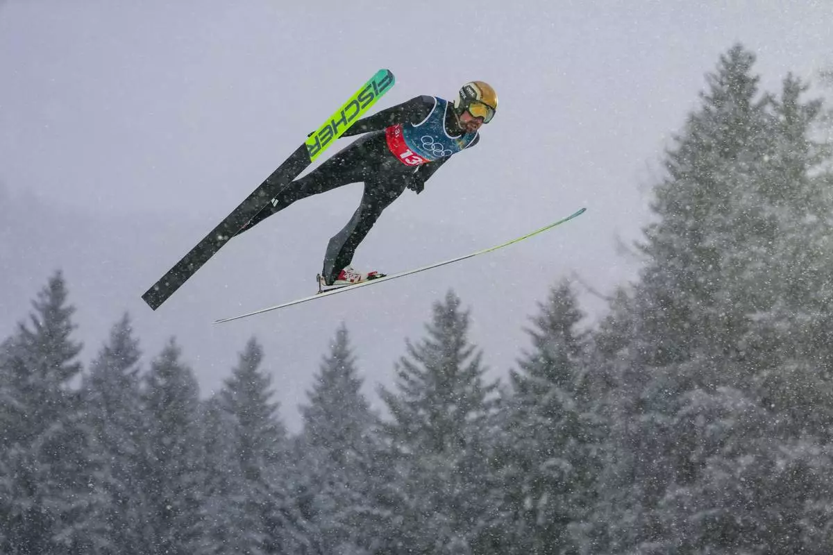Johannes Rydzek, of Germany, soars through the air during the nordic combined team sprint at the 2026 Winter Olympics, in Predazzo, Italy, Thursday, Feb. 19, 2026. (AP Photo/Evgeniy Maloletka)