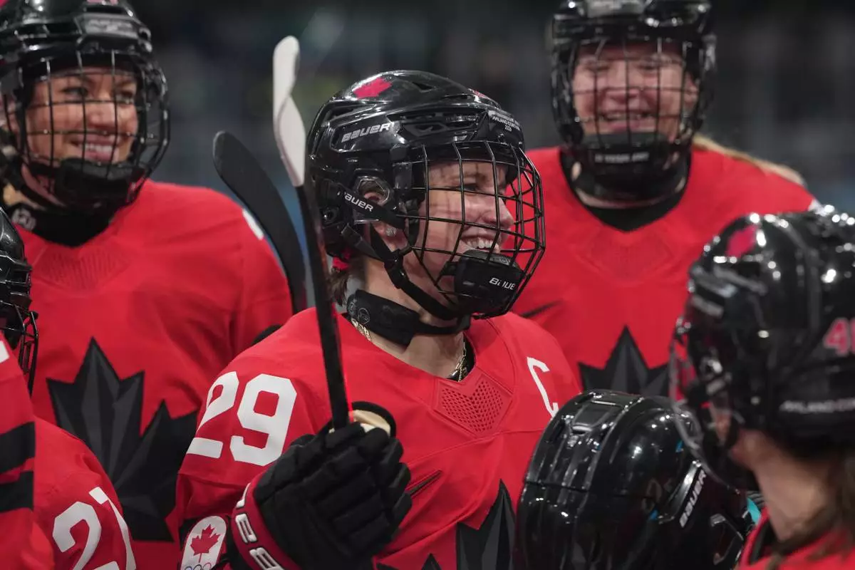Canada's Marie-Philip Poulin (29) gathers with teammates during warmups before a preliminary round match of women's ice hockey against Czechia at the 2026 Winter Olympics, in Milan, Italy, Monday, Feb. 9, 2026. (AP Photo/Carolyn Kaster)