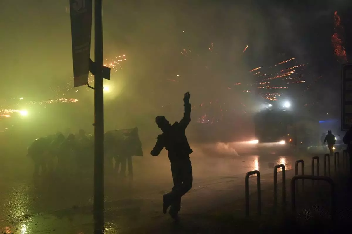 Demonstrators clash with police during a protest against the Milan-Cortina 2026 Olympics, in Milan, Italy, Saturday Feb. 7, 2026. (Claudio Furlan/LaPresse via AP)