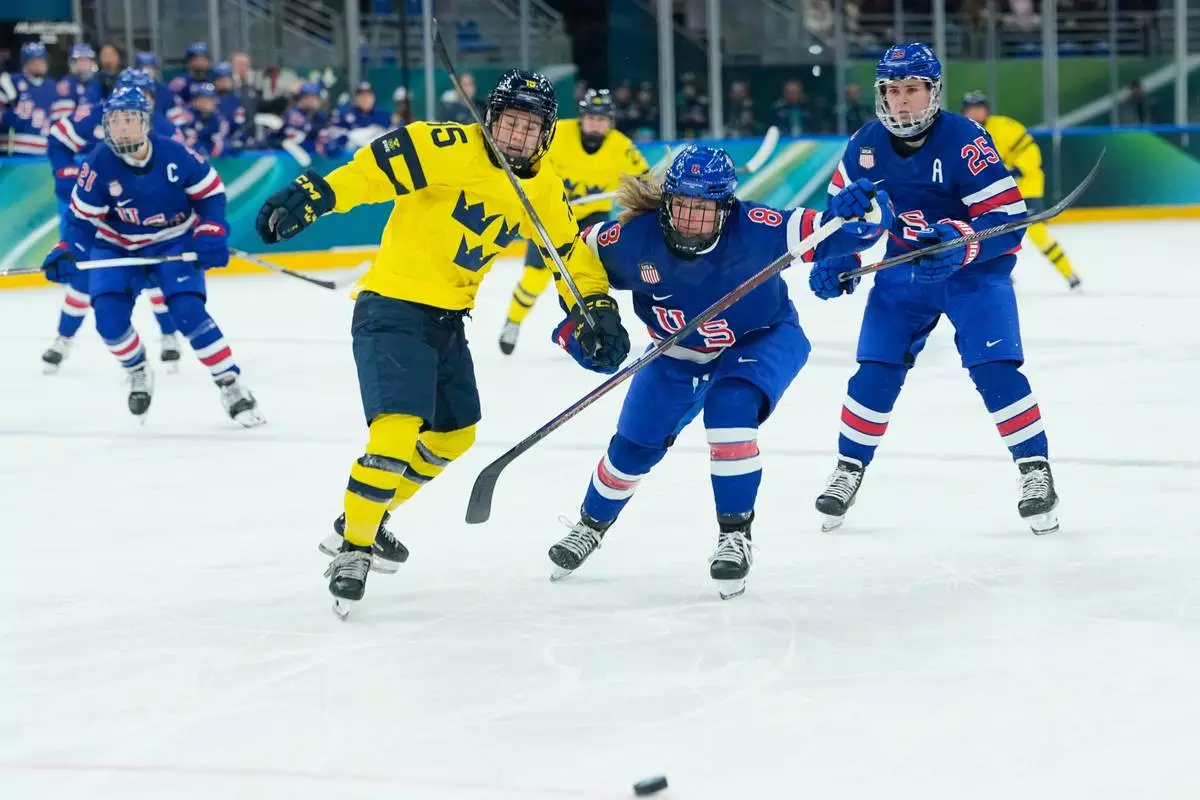 United States' Haley Winn, right, challenges for the puck with Sweden's Lisa Johansson during a semifinal match of women's ice hockey between the United States and Sweden at the 2026 Winter Olympics, in Milan, Italy, Monday, Feb. 16, 2026. (AP Photo/Petr David Josek)