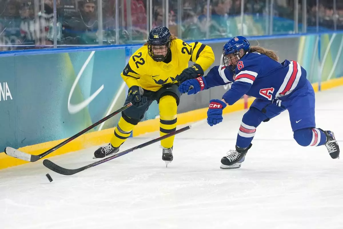 Sweden's Hanna Thuvik (22) is challenged by United States' Haley Winn (8) during a women's ice hockey semifinal game between the United States and Sweden at the 2026 Winter Olympics, in Milan, Italy, Monday, Feb. 16, 2026. (AP Photo/Hassan Ammar)