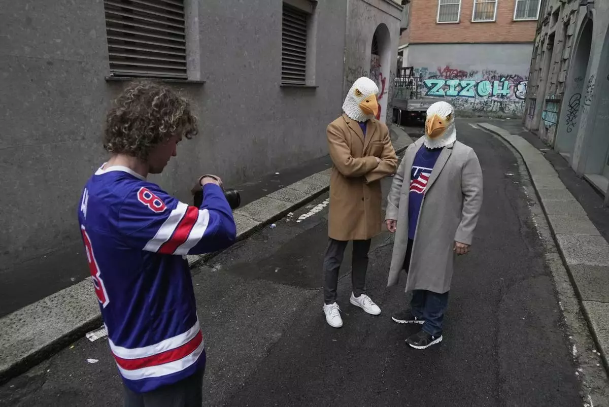 Ryan Winn films Casey Winn and Mitchell Hanson in a promotional video for the Winn's sister, Haley Winn, and the rest of the USA women's hockey team, Thursday, Feb. 19, 2026, in Milan, Italy. (AP Photo/Brittany Peterson)