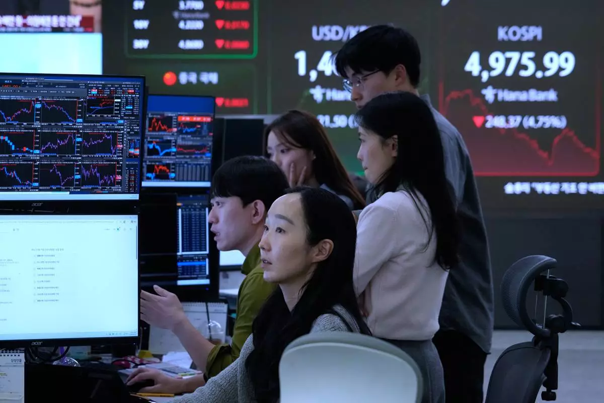 Currency traders watch monitors near a screen showing the Korea Composite Stock Price Index (KOSPI), top right, at the foreign exchange dealing room of the Hana Bank headquarters in Seoul, South Korea, Monday, Feb. 2, 2026. (AP Photo/Ahn Young-joon)