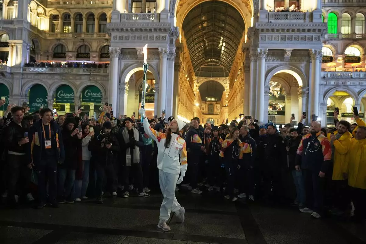 Ballet dancer Nicoletta Manni carries the Olympic torch flame, near the Duomo gothic cathedral, at the 2026 Winter Olympics, in Milan, Italy, Thursday, Feb. 5, 2026.(AP Photo/Francisco Seco)