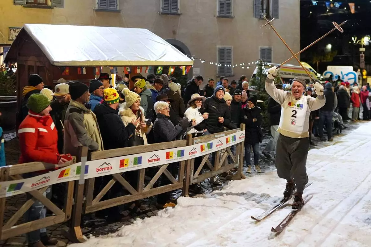 Spectators watch as Bormio residents participate in an annual cross-country ski race through the streets of the old town, this year coinciding with the 2026 Winter Olympics, in Bormio, Italy, Friday, Feb. 13, 2026. (AP Photo/Rebecca Blackwell)