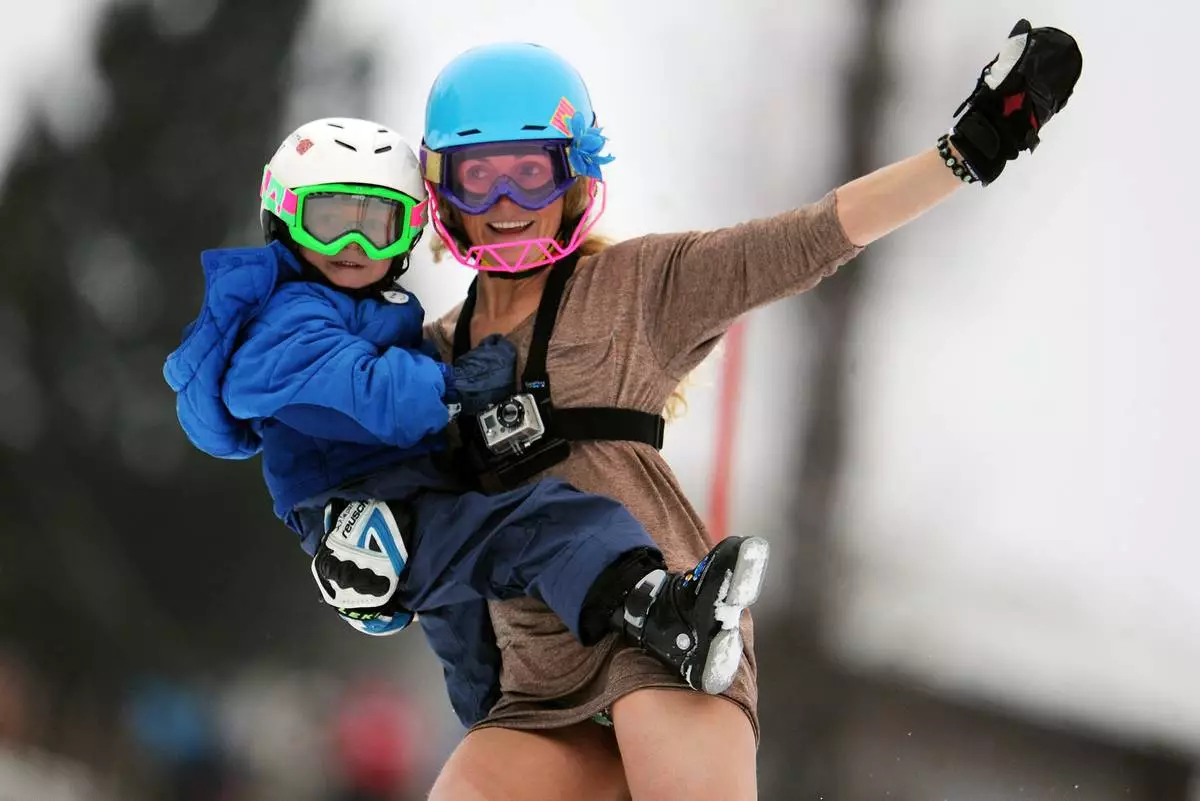 FILE - Sarah Schleper holds her son Lasse as she skies down the course during an alpine ski, women's World Cup slalom, in Lienz, Austria, Thursday, Dec. 29, 2011. (AP Photo/Giovanni Auletta, File)