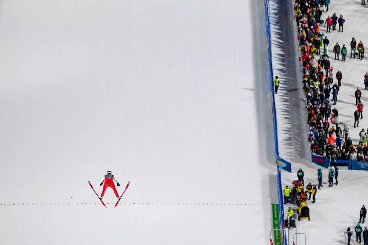 Johann Andre Forfang, of Norway, soars through the air during his trial jump of the ski jumping men's super team competition at the 2026 Winter Olympics, in Predazzo, Italy, Monday, Feb. 16, 2026. (AP Photo/Matthias Schrader)