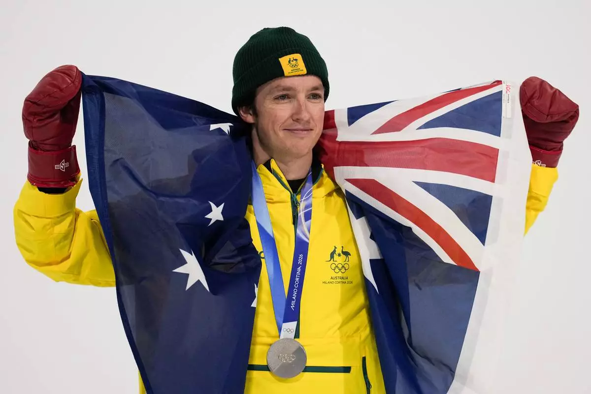 Silver medalist Australia's Scotty James holds an Australian flag after the men's snowboarding halfpipe finals at the 2026 Winter Olympics, in Livigno, Italy, Friday, Feb. 13, 2026. (AP Photo/Gregory Bull)