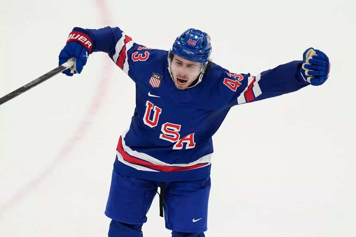 United States' Quinn Hughes celebrates after scoring the winning goal against Sweden during the overtime period of a men's ice hockey quarterfinal game at the 2026 Winter Olympics, in Milan, Italy, Wednesday, Feb. 18, 2026. (AP Photo/Hassan Ammar)