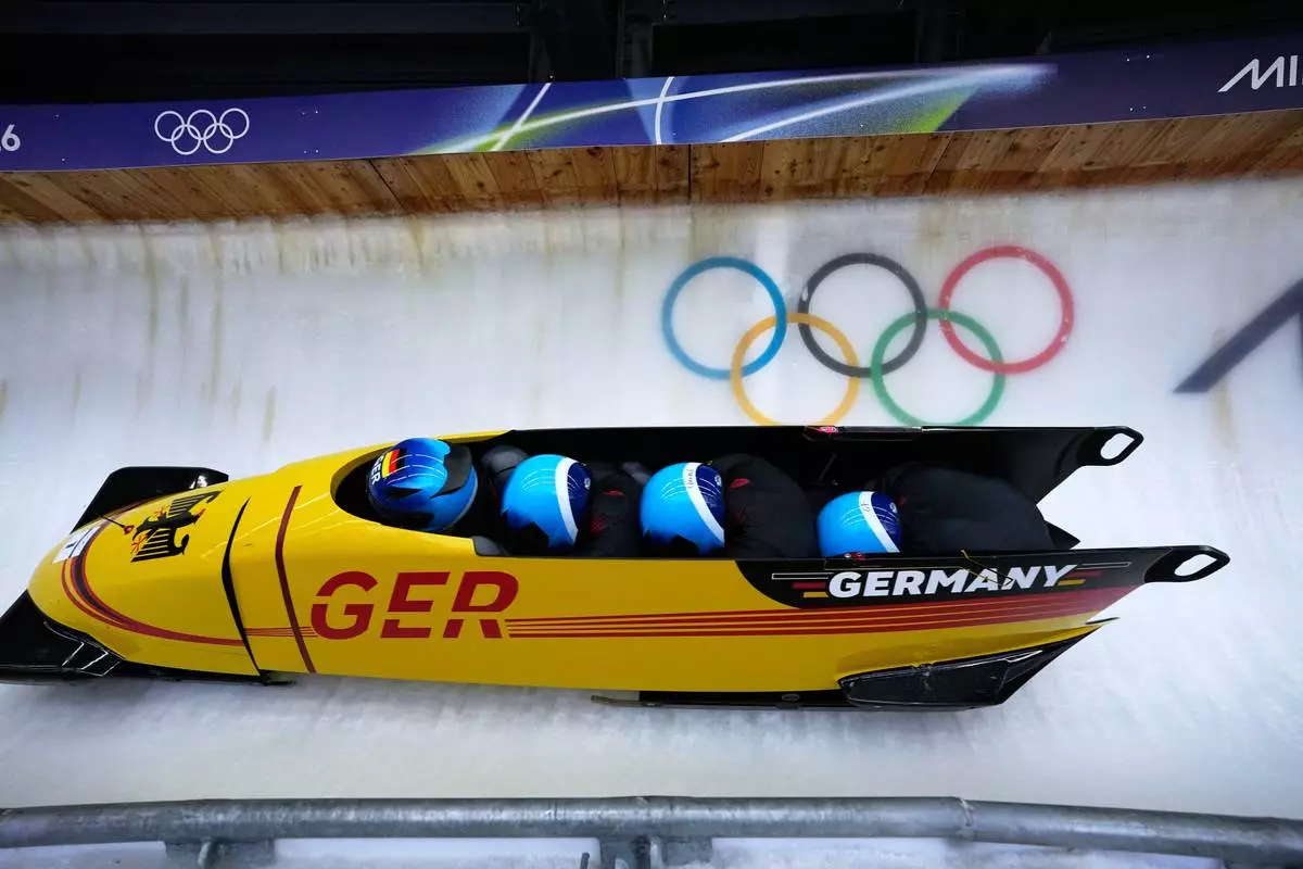 Germany's Johannes Lochner, left, Thorsten Margis, Jorn Wenzel and Georg Fleischauer slide down the track during a four man bobsled run at the 2026 Winter Olympics, in Cortina d'Ampezzo, Italy, Saturday, Feb. 21, 2026. (AP Photo/Aijaz Rahi)