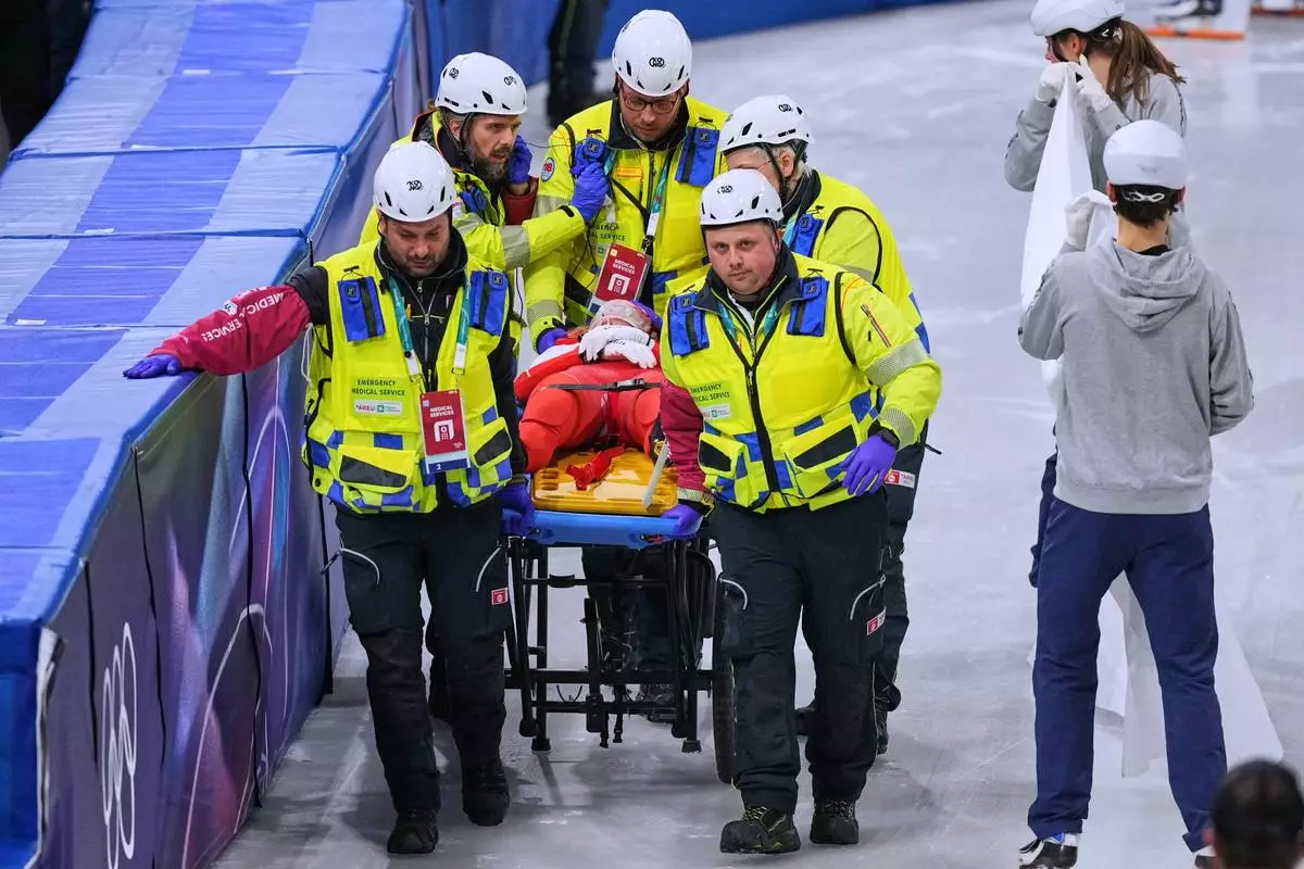 Kamila Sellier of Poland is helped after falling during a short track speed skating women's 1500 meters quarterfinal at the 2026 Winter Olympics, in Milan, Italy, Friday, Feb. 20, 2026. (AP Photo/Stephanie Scarbrough)