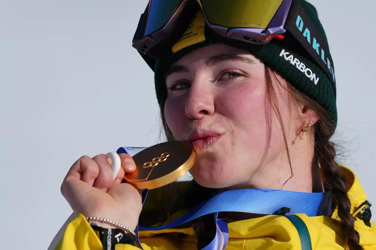 Gold medalist Australia's Josie Baff kisses her medal after winning the women's snowboard cross finals at the 2026 Winter Olympics, in Livigno, Italy, Friday, Feb. 13, 2026. (AP Photo/Julia Demaree Nikhinson)