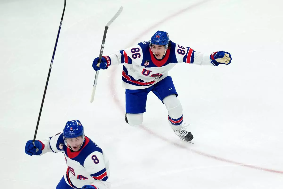 United States' Jack Hughes (86) and Zach Werenski (8) celebrate after Hughes scored the winning goal against Canada during the overtime period of the men's ice hockey gold medal game at the 2026 Winter Olympics in Milan, Italy, Sunday, Feb. 22, 2026. (AP Photo/Carolyn Kaster)