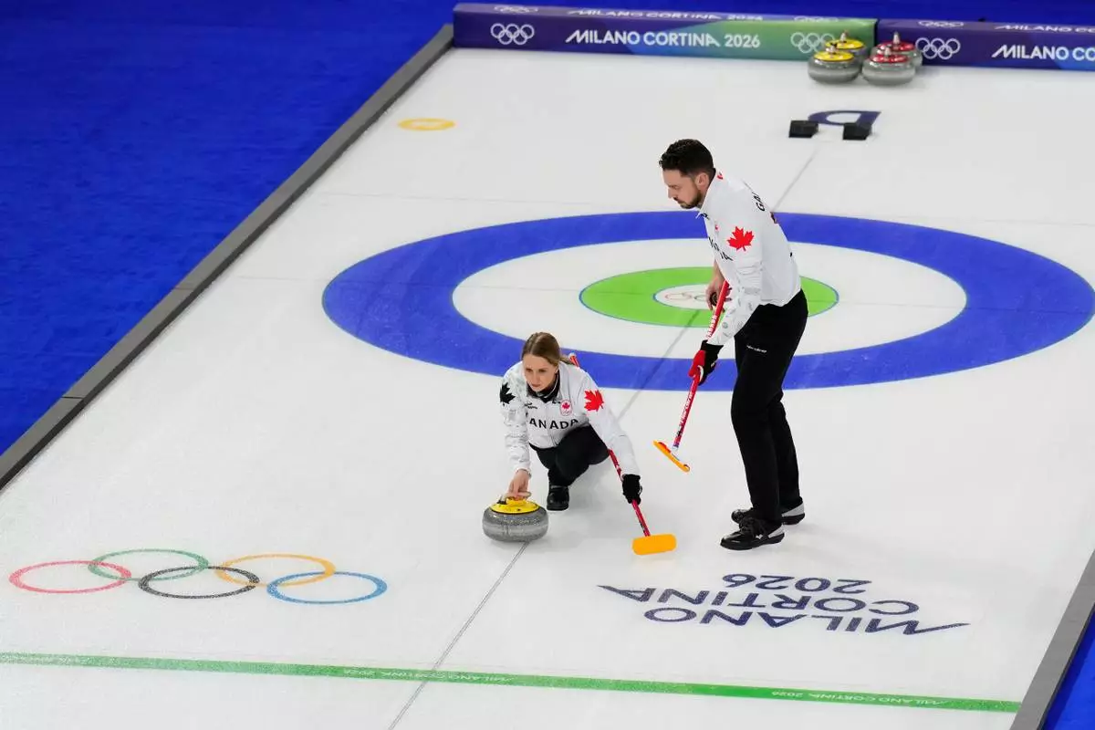 Jocelyn Peterman and Brett Gallant, of Canada, compete during a curling mixed doubles round robin session at the 2026 Winter Olympics, in Cortina d'Ampezzo, Italy, Friday, Feb. 6, 2026. (AP Photo/David J. Phillip)