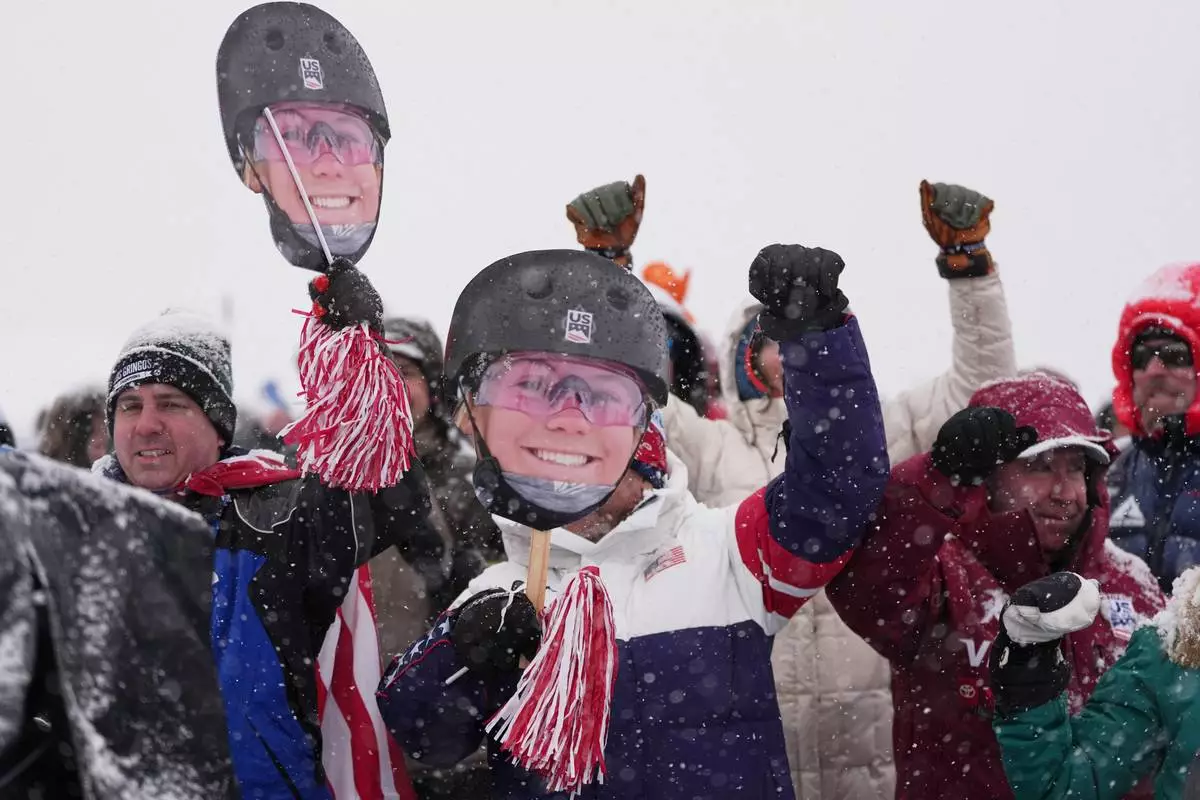 Fans for United States' Kyra Dossa brave heavy snow during a weather delay before women's freestyle skiing aerials qualifications at the 2026 Winter Olympics, in Livigno, Italy, Tuesday, Feb. 17, 2026. (AP Photo/Gregory Bull)