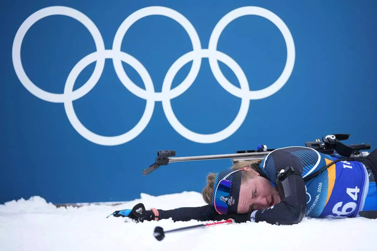 Johanna Talihaerm, of Estonia, collapses in the finish area of the women's 4x6-kilometer relay biathlon race at the 2026 Winter Olympics in Anterselva, Italy, Wednesday, Feb. 18, 2026. (AP Photo/Andrew Medichini)