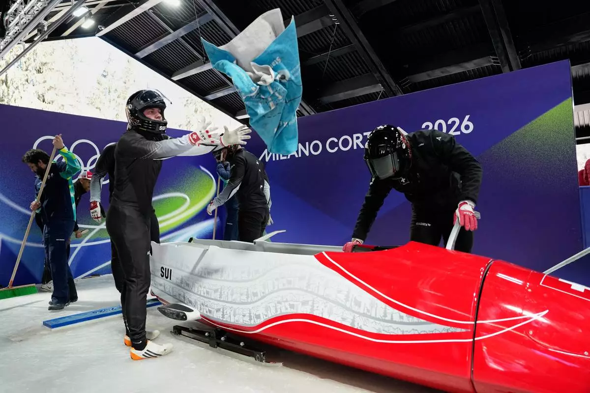 Switzerland's Michael Vogt and his team prepare to start for a four man bobsled training session at the 2026 Winter Olympics, in Cortina d'Ampezzo, Italy, Wednesday, Feb. 18, 2026. (AP Photo/Alessandra Tarantino)