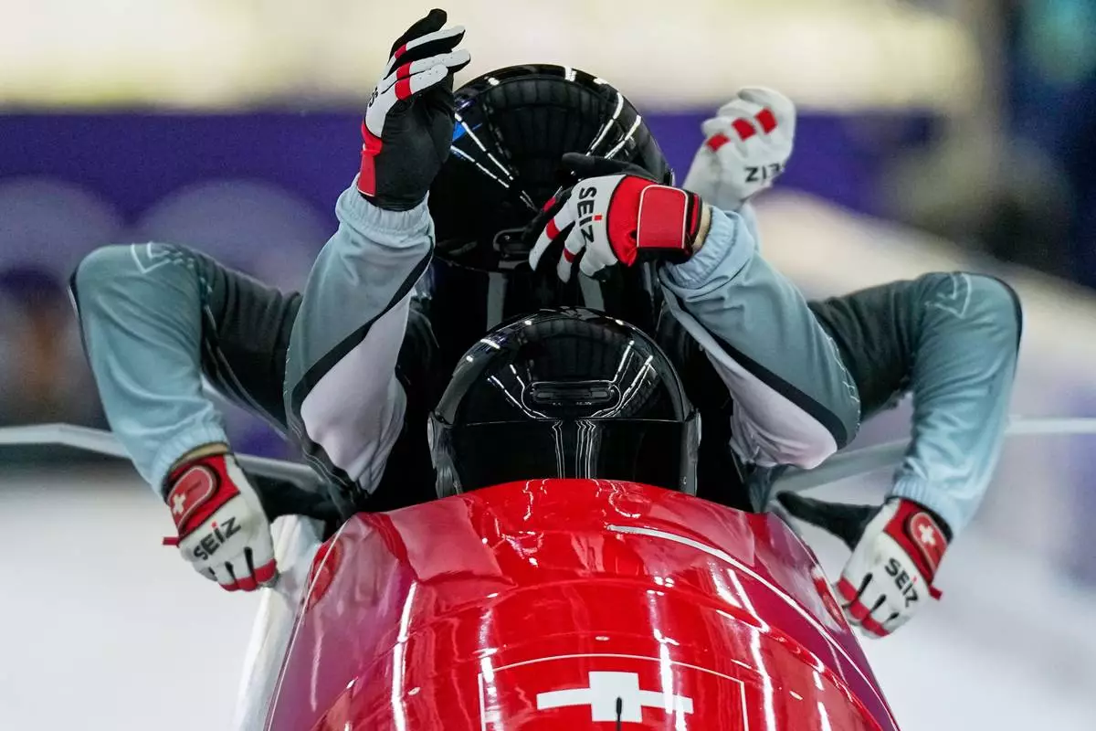Switzerland's Timo Rohner, front, starts for a four man bobsled training session at the 2026 Winter Olympics, in Cortina d'Ampezzo, Italy, Wednesday, Feb. 18, 2026. (AP Photo/Aijaz Rahi)