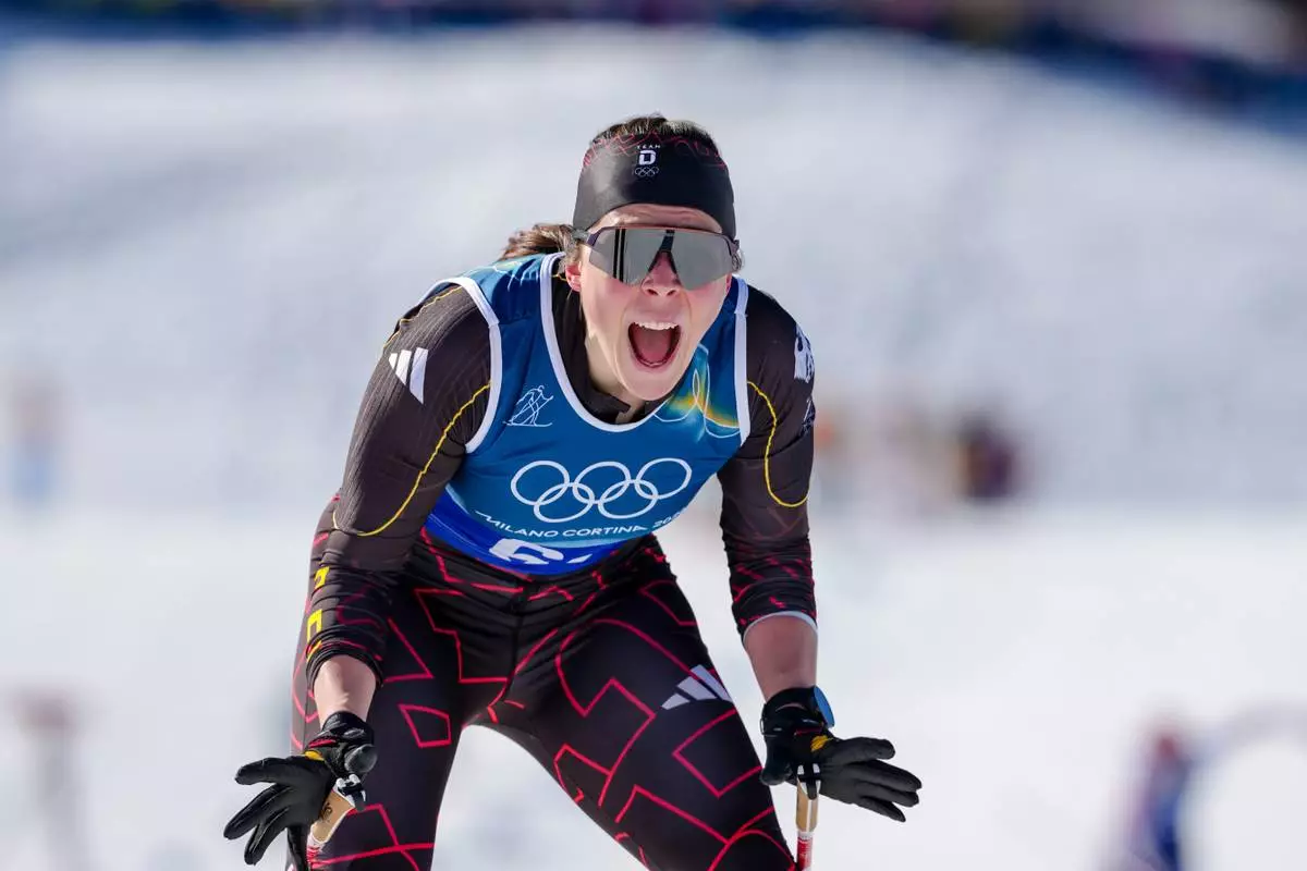 Coletta Rydzek, of Germany, reacts after crossing the finish line to win the bronze medal in the cross-country skiing women's team sprint free at the 2026 Winter Olympics, in Tesero, Italy, Wednesday, Feb. 18, 2026. (AP Photo/Kirsty Wigglesworth)