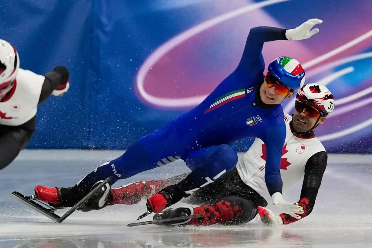 Maxime Laoun of Canada and Pietro Sighel of Italy collide during the short track speed skating men's 500m at the 2026 Winter Olympics, in Milan, Italy, Wednesday, Feb. 18, 2026. (AP Photo/Ashley Landis)