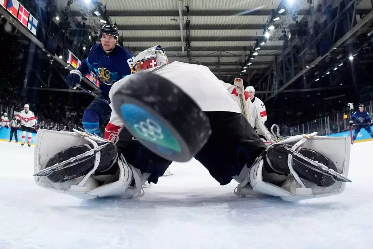 Finland's Artturi Lehkonen (62) scores his side's third goal during a men's ice hockey quarterfinal game between Finland and Switzerland at the 2026 Winter Olympics, in Milan, Italy, Wednesday, Feb. 18, 2026. (AP Photo/Petr David Josek, Pool)